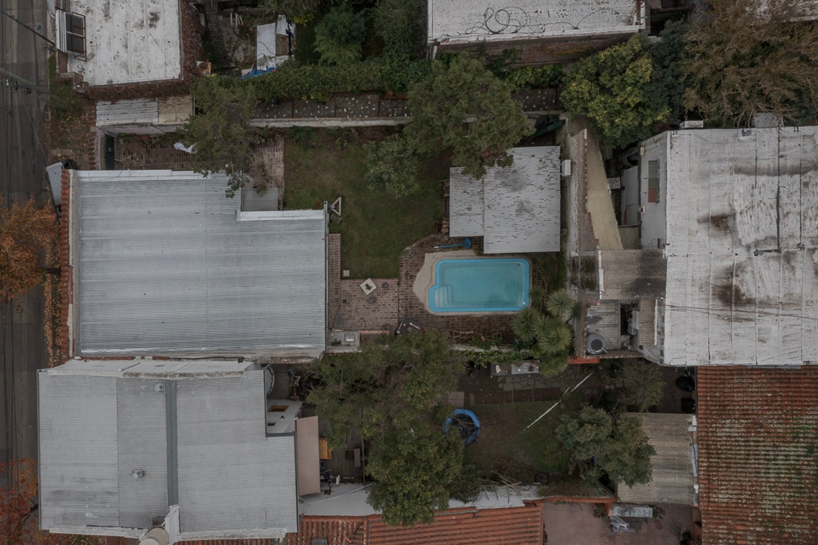 piscina residencial en patio trasero suburbano — proyecto Reforma Navarro, por Estudio YME, en B1648 Tigre